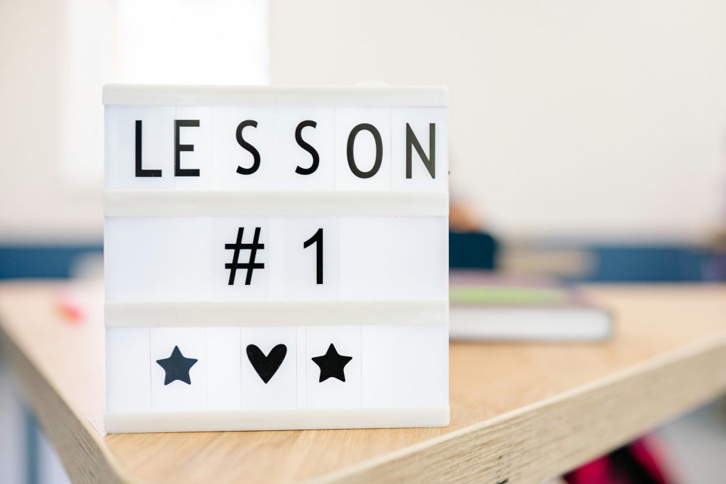 pexels photo 8617774 8617774 Lightbox sign displaying 'Lesson #1' in a classroom setting, symbolizing education and new beginnings.